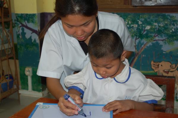 A special educator helps a child with a disability
